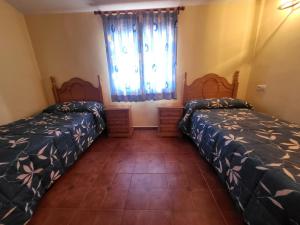 1 dormitorio con 2 camas y una ventana con cortinas en Casa rural CASA DEL CERRO, en Casas del Cerro