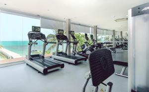 a gym with treadmills and chairs in a room with the ocean at InterContinental Koh Samui Resort, an IHG Hotel - SHA Extra Plus in Taling Ngam Beach