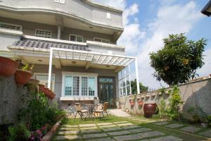 a house with a table and chairs in the yard at Vineyard Guest House in Taitung City