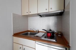 a small kitchen with a sink and a stove at Elia mini suites 5 in Larisa