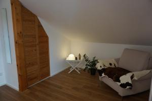 Habitación con silla, mesa y puerta en Ferienwohnung Jenbachtal, en Bad Feilnbach