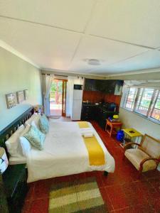 a bedroom with a large bed and a kitchen at Hakuna Matata in Wilderness