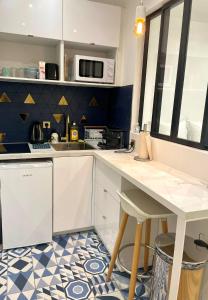 a kitchen with a white counter and a table at Appartement Vincennes proche métro 15 minutes Marais in Vincennes