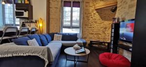 uma sala de estar com um sofá azul e uma televisão em Appartement DIJON Cité de la Gastronomie et du Vin - Arquebuse-Gare - A deux pas de toutes les commodités em Dijon