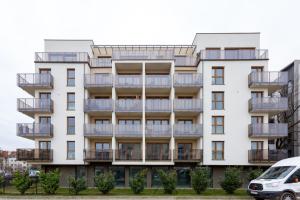 an apartment building with balconies and a van parked in front at Studio w centrum- Villa Wenecja in Poznań