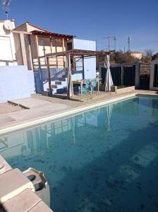 a swimming pool with a table and chairs in front of a house at mas de lavande in Saint-Ambroix +8 photos