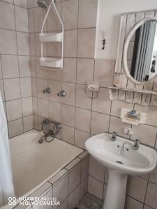 a bathroom with a sink and a tub and a mirror at Sea Scapes Holiday Apartment in Margate