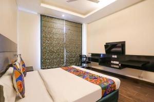 a hotel room with a bed and a piano at FabHotel Posh Classic in Gurgaon
