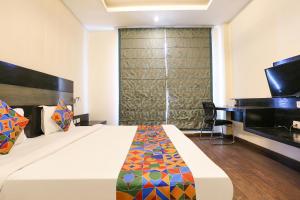 a hotel room with a bed and a television at FabHotel Posh Classic in Gurgaon