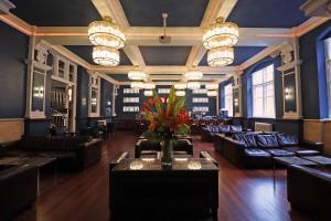 Morgans Hotel في سوانسي: غرفة كبيرة مع أرائك و إناء من الزهور