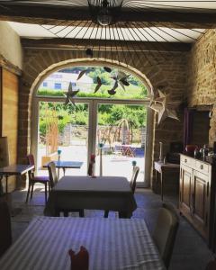 comedor con mesa y ventana en L'Entre-Coeur, en Ménétru-le-Vignoble