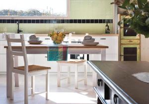 cocina con mesa, sillas y barra en 17pounds Country Estate & Aqua Wellness Retreat, en Bullarto