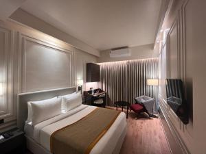 a hotel room with a large bed and a desk at Hotel Poonja International in Mangalore