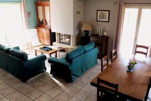 弗朗舍維爾的住宿－La Maison des Palombes，客厅配有2张蓝色的沙发和1张桌子