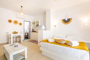 - une chambre blanche avec un lit et une table dans l'établissement Anemos Guest Apts, à Karpathos