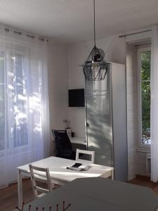 a dining room with a white table and a desk at Le Coeur, Studio central refait à neuf, au calme in Besançon