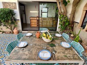 una mesa con platos y una cesta de fruta. en Villa Sa Torre Blanca, en Colonia de San Pedro