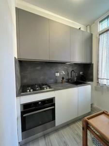 a kitchen with white cabinets and a stove top oven at Appartamento in zona Bocconi in Milan