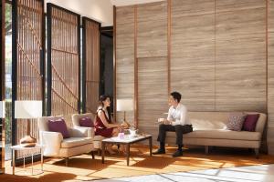 a man and woman sitting on a couch in a lobby at Amari Don Muang Airport Bangkok in Bangkok