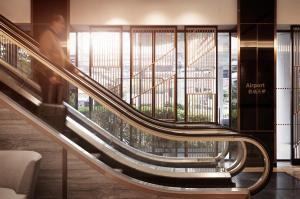 a person riding an escalator in a building at Amari Don Muang Airport Bangkok in Bangkok