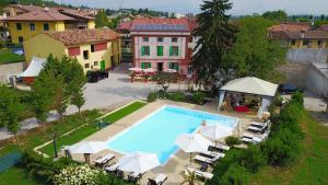 an overhead view of a swimming pool with umbrellas and a house at B&B Villa Rossella con piscina in Castelnuovo del Garda