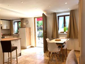 a kitchen and dining room with a table and chairs at Ferienwohnung 3 Rinser in Vogtareuth