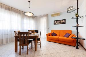 We Home - HOUSE OF STARS - Bologna في بولونيا: غرفة معيشة مع أريكة برتقالية وطاولة