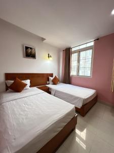 a hotel room with two beds and a window at Valentine Luxury hotel - 31 Bui Vien Street in Ho Chi Minh City