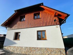 ein Haus mit einem orangenen Dach darüber in der Unterkunft Chalupa Luční Kvítí in Petrovice