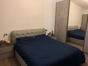 ein Schlafzimmer mit einem blauen Bett und zwei Spiegeln in der Unterkunft Attico con terrazzo. in Parma