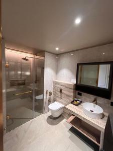 y baño con aseo, lavabo y ducha. en Hotel Poonja International, en Mangalore