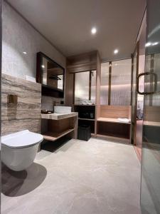 a bathroom with a toilet and a sink and a tub at Hotel Poonja International in Mangalore
