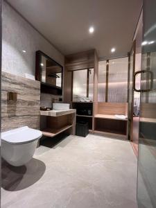 Hotel Poonja International في منغالور: حمام مع مرحاض ومغسلة وحوض استحمام