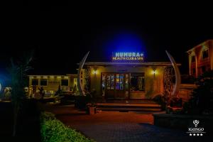 a building with a blue sign on it at night at Igongo Country Hotel & Cultural Centre in Kyabinunga