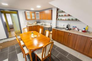 a kitchen with a wooden table and wooden cabinets at Barkóscinege Vendégház in Géberjén