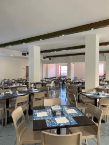 una sala da pranzo con tavoli e sedie di Hotel Aron a Rimini