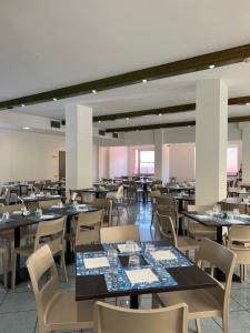 a dining room filled with tables and chairs at Hotel Aron in Rimini