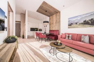 ein Wohnzimmer mit einem rosa Sofa und einem Tisch in der Unterkunft Die Zillertalerin in Uderns