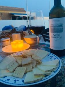 un plato de queso y una botella de vino en Ático con vistas al mar, en Balerma