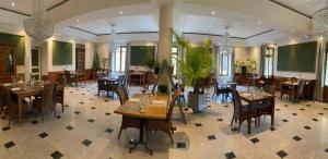 restauracja ze stołami i krzesłami w pokoju w obiekcie Logis - Hotel Restaurant du Parc w mieście Cransac