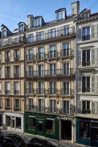 - un grand bâtiment avec des balcons sur le côté dans l'établissement Grand Hôtel Malher, à Paris