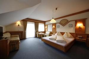 a hotel room with a bed and a table and chairs at Bankwirt in Schladming