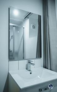 a bathroom with a sink and a large mirror at Appartement neuf et moderne dans le centre ville in Bagnols-sur-Cèze