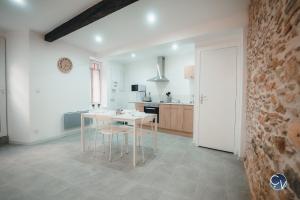 een keuken met een tafel en stoelen in een kamer bij Appartement neuf et moderne dans le centre ville in Bagnols-sur-Cèze