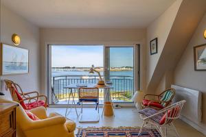 a living room with a table and chairs and a balcony at “Maison en bord de mer à Loctudy avec vue sur le jardin." in Loctudy