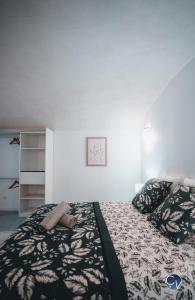 een slaapkamer met een bed met een zwart-wit dekbed bij Appartement neuf et moderne dans le centre ville in Bagnols-sur-Cèze