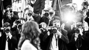 un groupe de personnes prenant des photos avec des caméras dans l'établissement Victoria, à Cannes