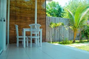 eine Veranda mit einem Tisch und 2 Stühlen darauf in der Unterkunft Villa Samalas Resort and Restaurant in Gili Meno