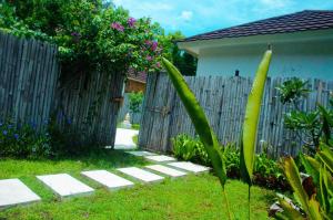 a backyard with a wooden fence and a garden at Villa Samalas Resort and Restaurant in Gili Meno