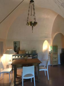 a dining room with a table and white chairs at Dammusi IL SERRALH -Pantelleria- in Pantelleria +188 photos